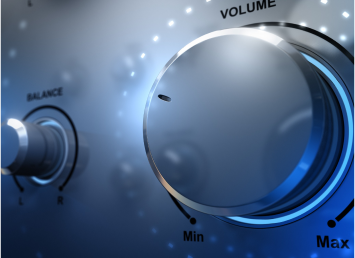 Close-up of a stereo control panel with a focus on a large volume knob. The knob is metallic, with labels "Min" and "Max" indicating volume levels. Smaller balance knob is visible to the left, against a softly lit, blue-toned background.